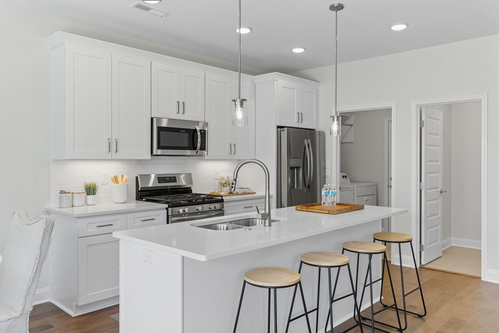 Poplar Creek modern kitchen with island, white cabinets, pendant lights, and premium finishes