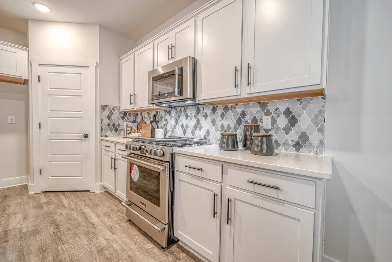 Allston modern kitchen with island, white cabinets, pendant lights, and premium finishes