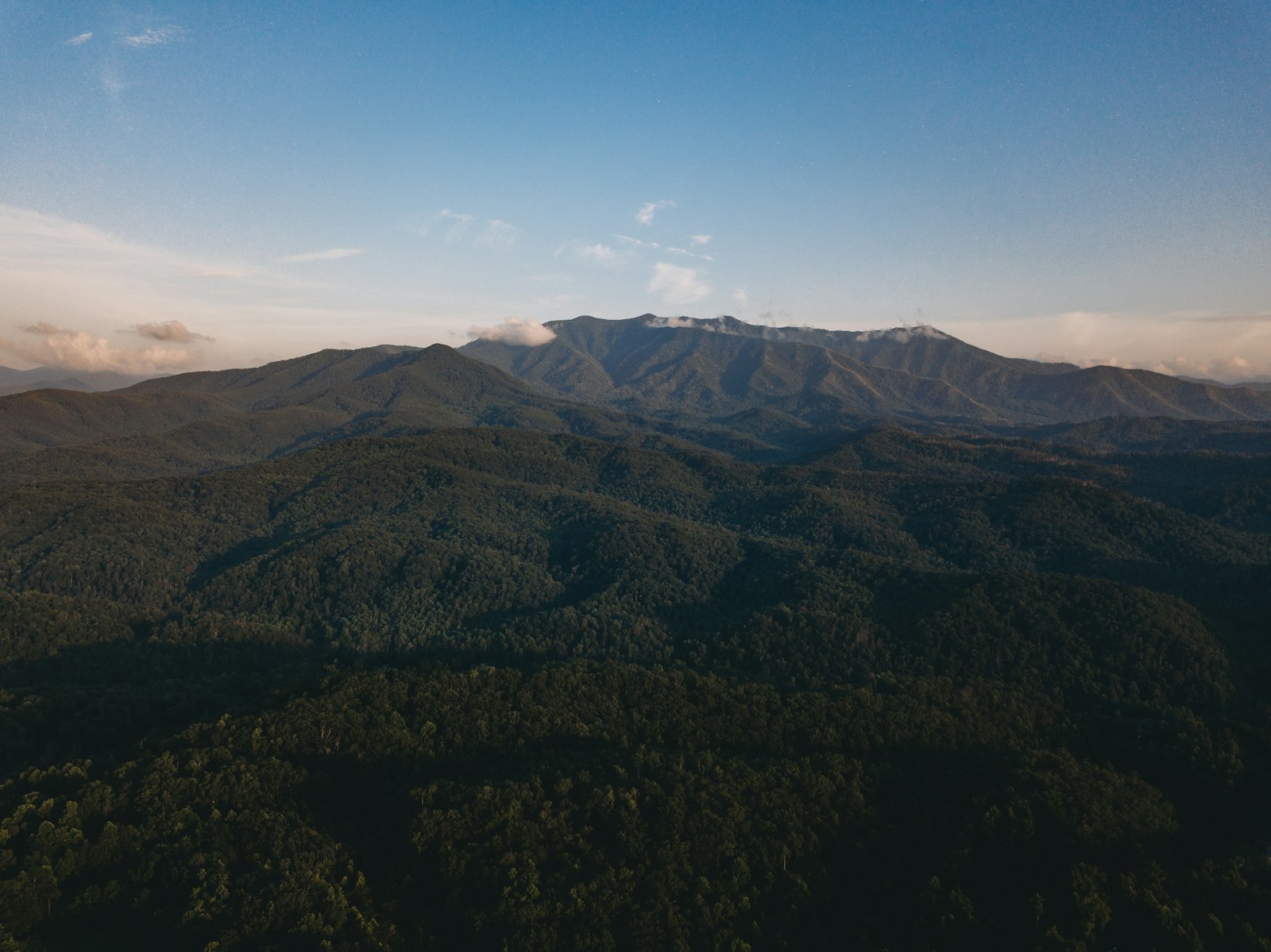 Aerial view of a forested Great Smoky Mountains ridge under a clear blue sky, about 45 minutes from Knoxville, Tennessee
